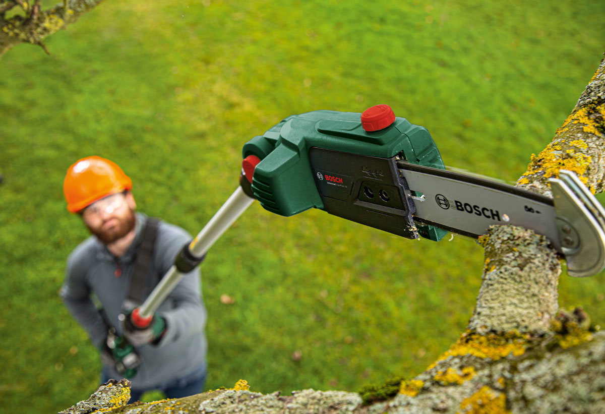 Άντρας κατά τη χρήση του κονταροπρίονου Bosch UniversalChainPole 18.