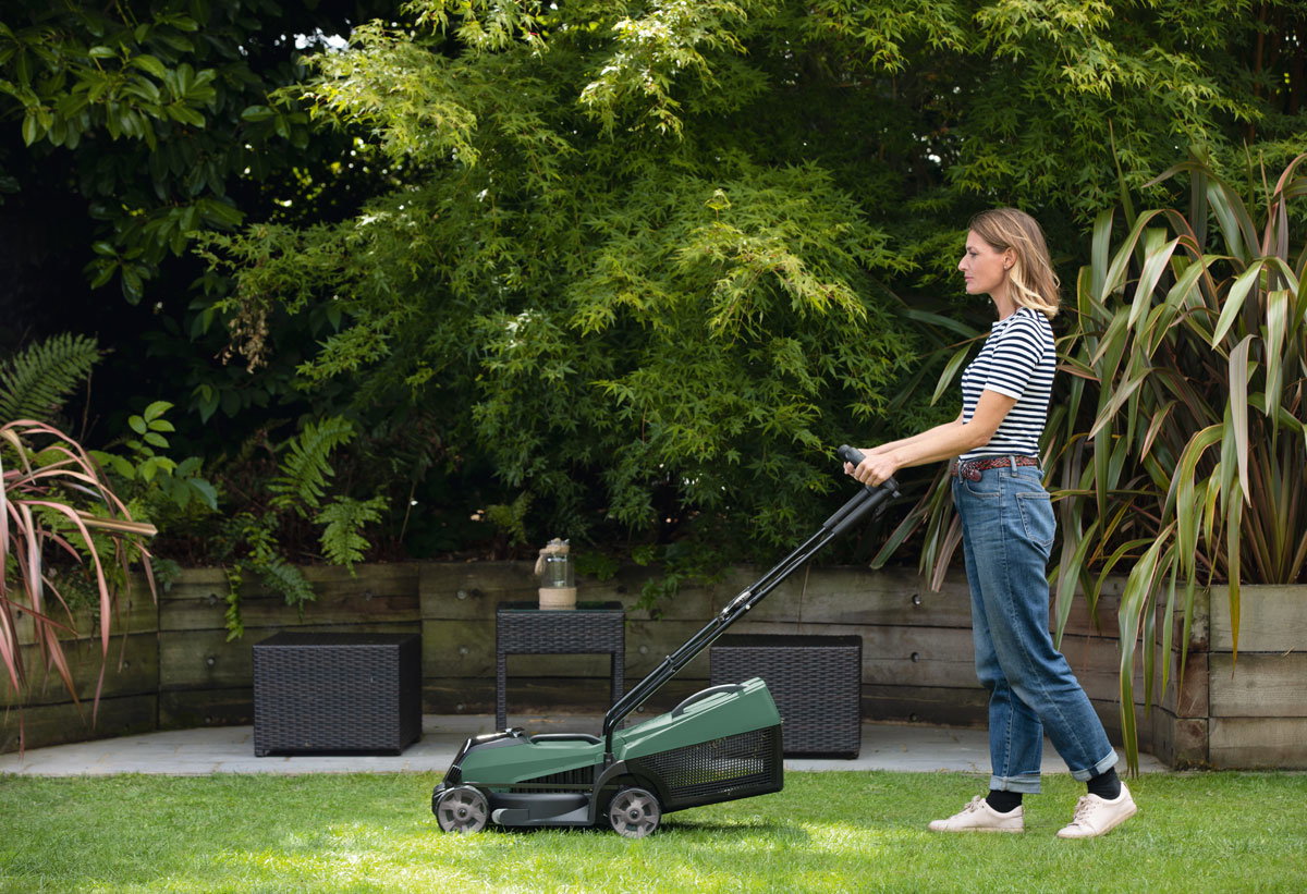 Μια γυναίκα χρησιμοποιεί το χλοοκοπτικό Citymower 18 της Bosch, διατηρώντας άνετη στάση σώματος.