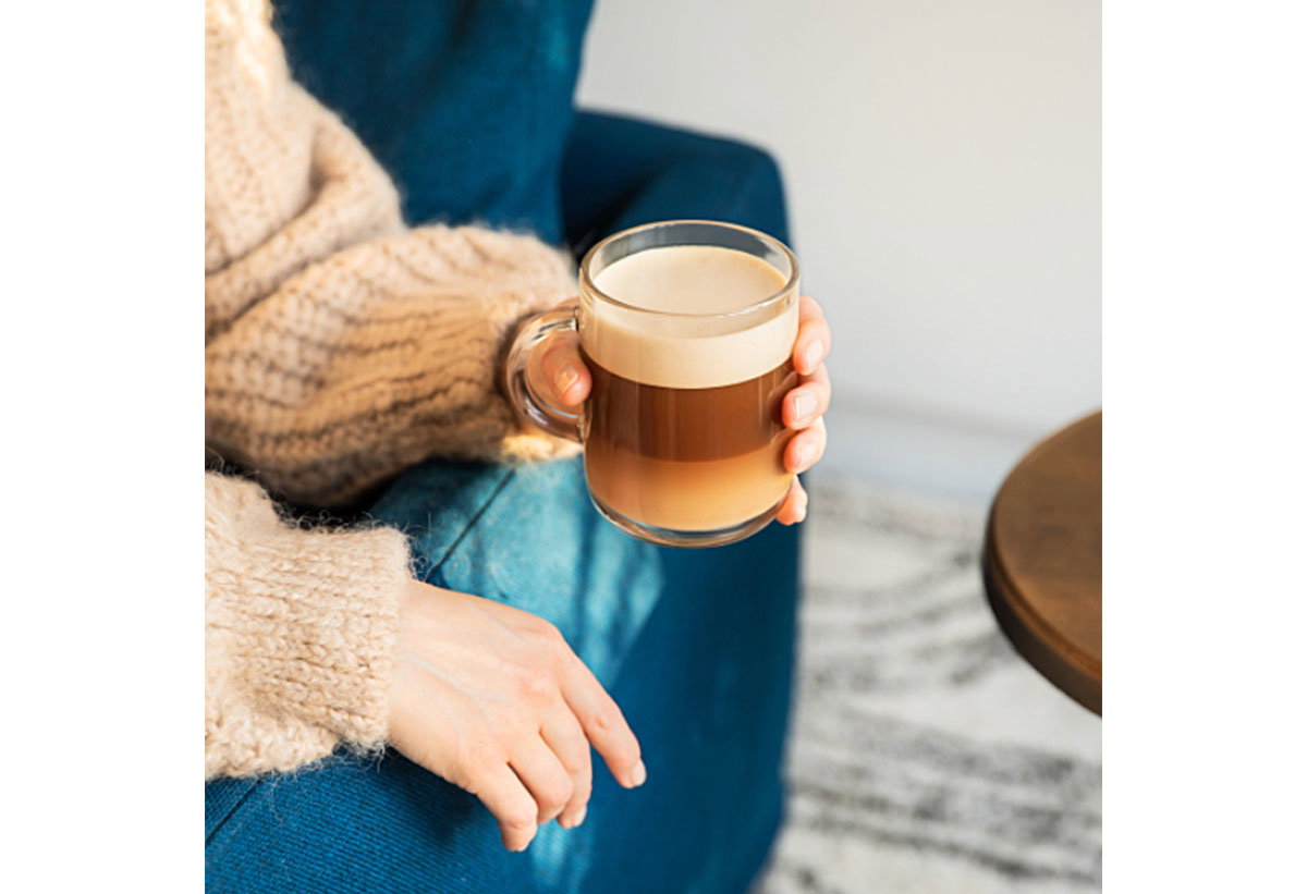 Μια γυναίκα κρατάει μια κούπα Cappuccino, σε φλυτζάνι Nespresso