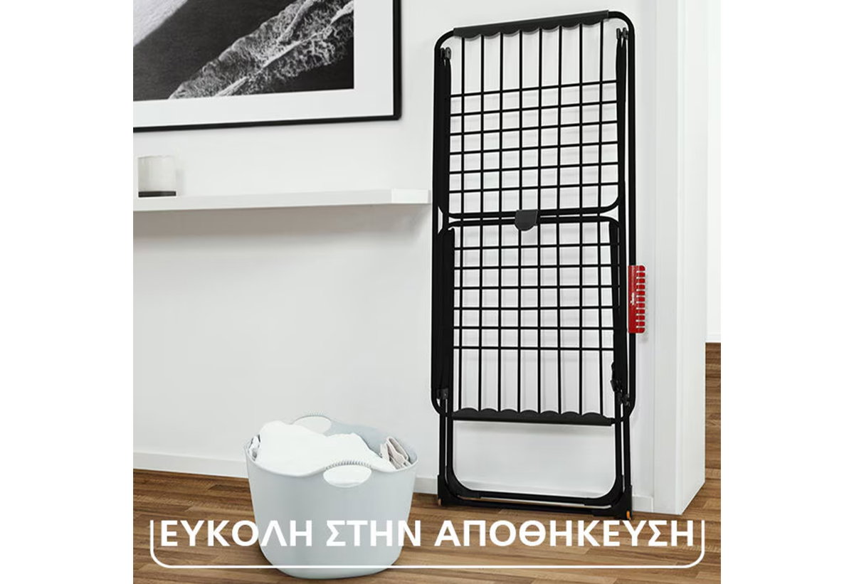 Απεικονίζεται η απλώστρα διπλωμένη και στηριγμένη σε έναν τοίχο.