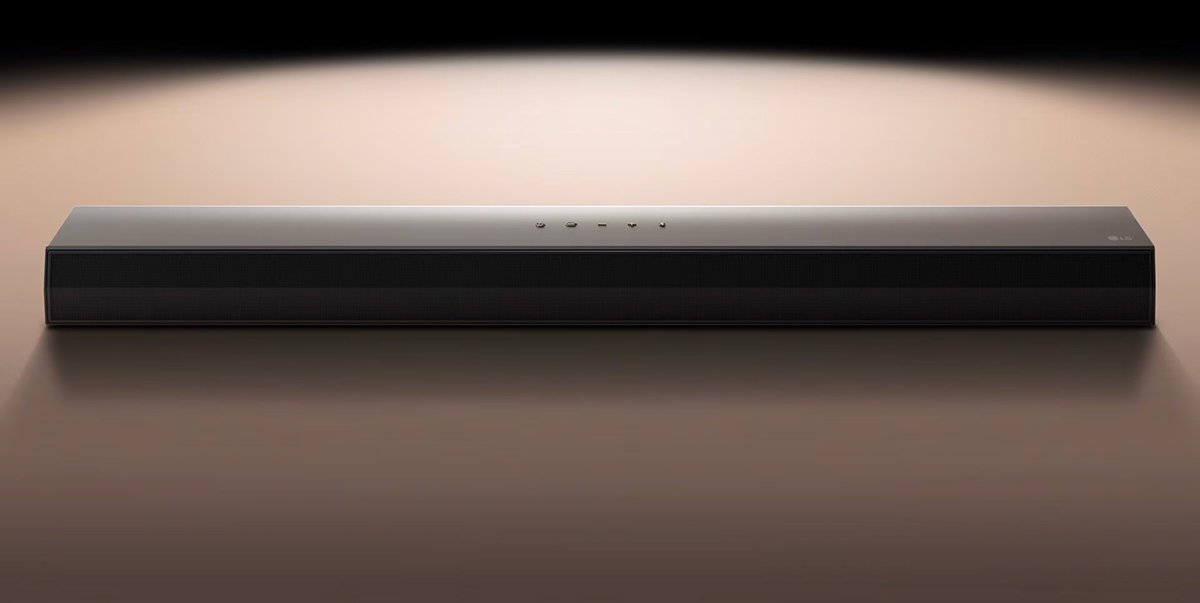 LG Soundbar μπροστά από μαύρο φόντο που φωτίζεται με προβολέα.