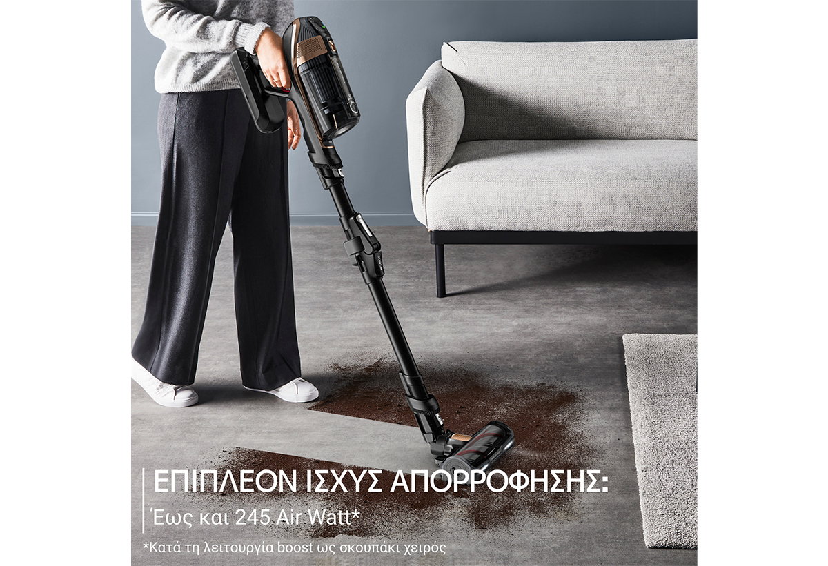 Απεικονίζεται γυναίκα να σκουπίζει χώμα σε σαλόνι.